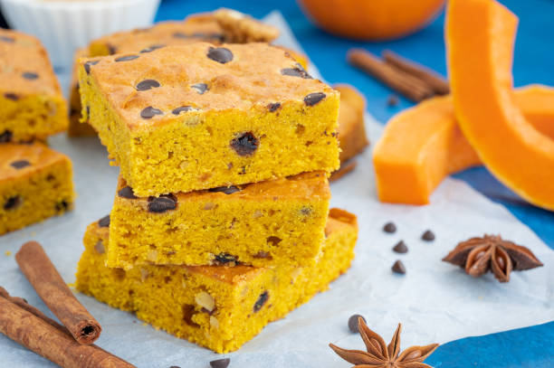 istock Pumpkin blondie or cake with chocolate drops, walnuts, cinnamon and anise on baking paper on a blue concrete background. Dessert for Thanksgiving or Halloween. 1425746977