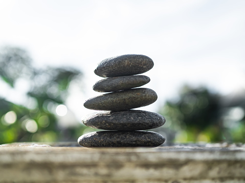 Stack Stone on Cement Wall Background.Pyramid Rock Cairn,Pebble SPiritual,Stability,Calm,Meditation Growth Symbols,Pile Zen Design Smooth for Vacation Relaxation Nature Aroma therapy Spa Set Concept.