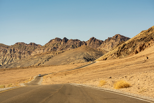 Cars driving on a remote Interstate road in the desert of Death Valley, California.