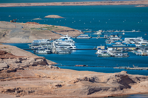 Aerial panorama view of the boats at Lake Powell near the city of Page on the border of Arizona and Utah, southwest USA. The water is a lot lower than it used to be due to climate change and high consumption of water.