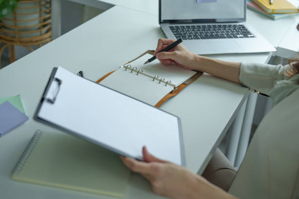 istock Portrait of an Asian bank employee using notebooks to take notes, budget documents and computers to close financial statements 1425773872