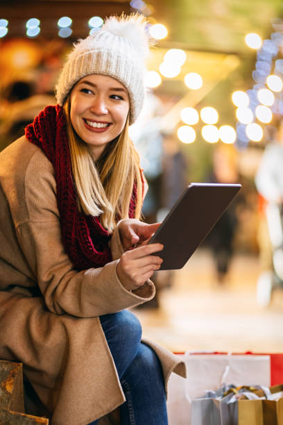 shopping christmas travel people concept. happy woman with shopping bag using digital device outdoor - ipad shopping gift retail imagens e fotografias de stock