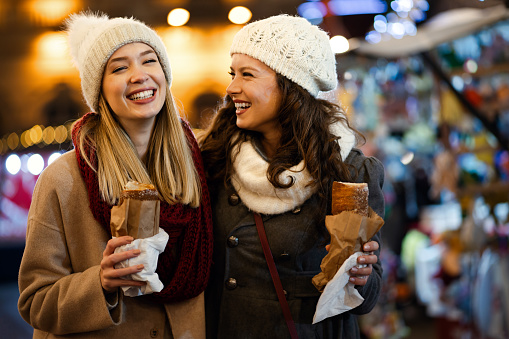 Happy woman friends enjoying time together on christmas market. Holiday christmas people happiness concept.