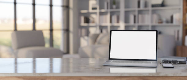 istock Workspace tabletop with laptop mockup and copy space over blurred modern living room 1425785682