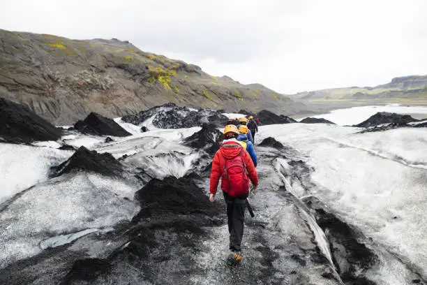 A teenage boy hiking on the Sólheimajökull glacier that is an outlet of the icecap of Mýrdalsjökull situated close to the Ring Road on the South Coast of Iceland.