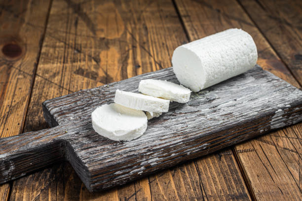 istock Sliced Soft Goat cheese on a cutting board. Wooden background. Top view 1425790400