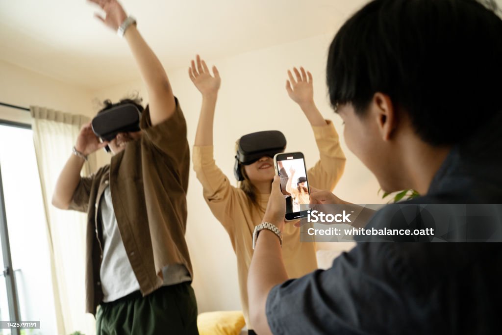 Friends dance using VR to add fun. Asian friends dance using VR to add fun. And another friend who filmed the video as their memories that were shared on holidays. 20-24 Years Stock Photo