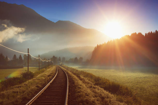 bahn und zug in den alpen bei sonnenaufgang - bayerische alpen stock-fotos und bilder