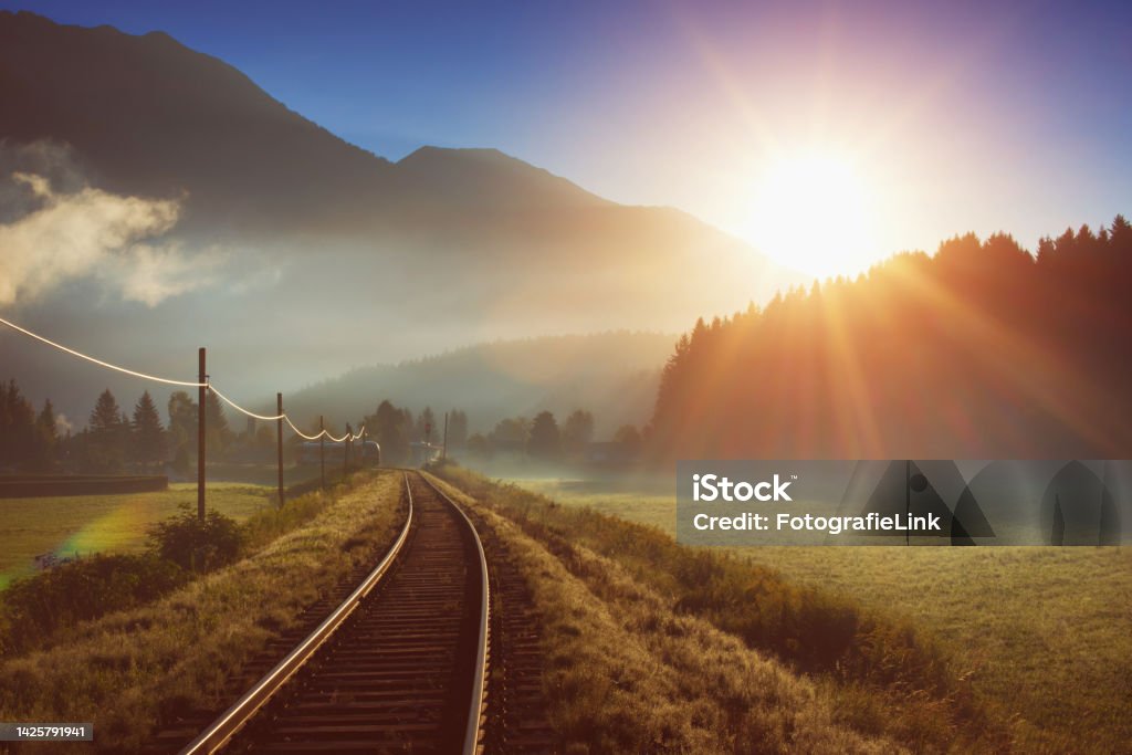 Railway and train in the Alpes at sunrise Train - Vehicle Stock Photo