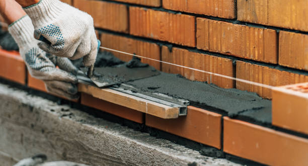 las llanas de albañil untan mortero de cemento sobre ladrillo. albañilería al construir una casa o una cerca de piedra - mason brick bricklayer installing fotografías e imágenes de stock