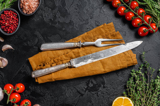 istock Rustic Cutting Board and meat fork on Dark  wooden board. Black background. Top view. Copy space 1425794010