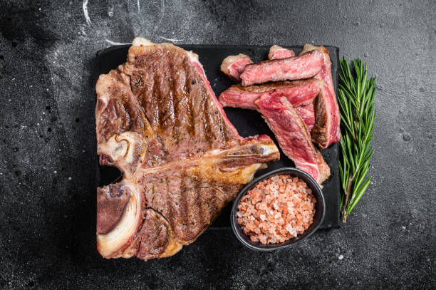 istock T bone grilled beef meat Steak, cooked Porterhouse on a marble board. Black background. Top view 1425794050