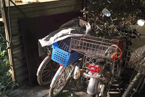 collection of abandoned delivery bikes and scotters, outdor shot