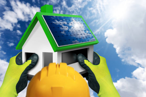 istock Construction Worker Holding a Small Model House with Solar Panels on the Roof 1425795709