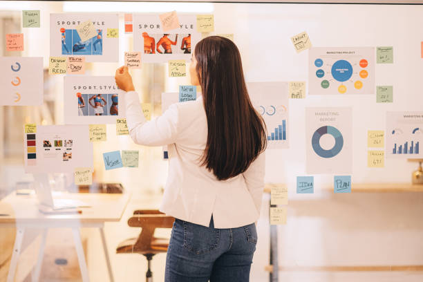 istock Business woman, marketing notes and creative planning, innovation ideas and project schedule in startup. Young designer, post it solution and branding management vision, logistics and glass strategy 1425796668