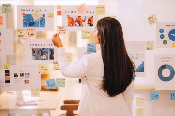 istock Marketing sticky note, reading reminder and planning creative idea business woman in work office, strategy for advertising company and data chart of growth. Employee thinking of vision for startup 1425796675