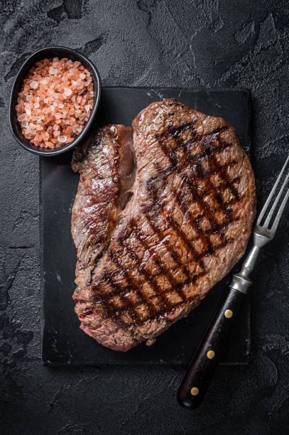 grilled top sirloin or rump steak on a marble board. black background. top view - top sirloin imagens e fotografias de stock