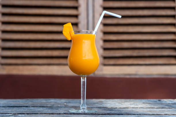 istock Freshly squeezed juice from mango in a glass goblet. Close up 1425797400