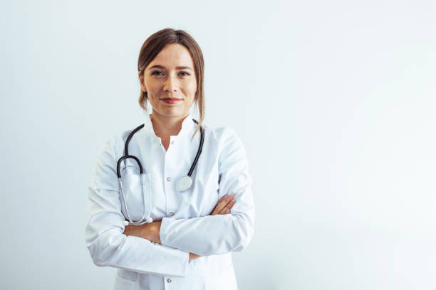 foto de una doctora confiada en el hospital, mirando a la cámara con una sonrisa. - doctora fotografías e imágenes de stock