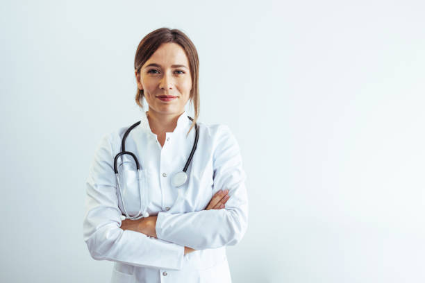 Photo of confident female doctor in hospital, looking at camera with smile. Photo of confident female doctor in hospital, looking at camera with smile. female doctor stock pictures, royalty-free photos & images
