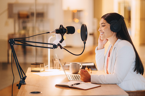 Podcast, presenter broadcast and woman recording in studio for online audio interview followers. Influencer host show for opinion, debate and public thoughts with streaming app on the internet.