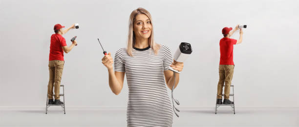 istock Workers installing cameras and a casual young woman holding cctv 1425809253