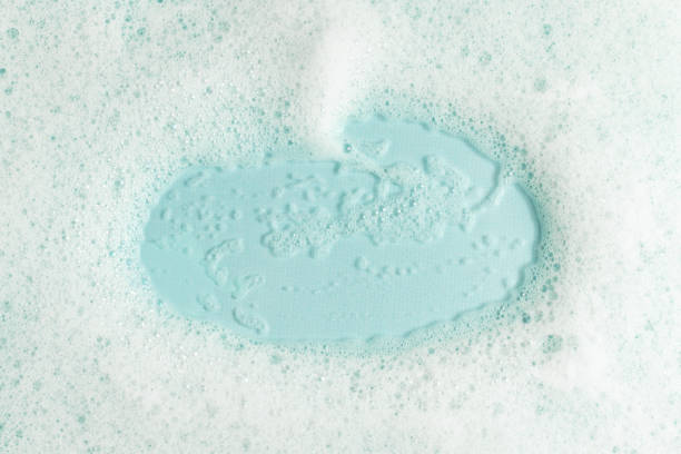 istock White fluffy soap foam on blue background. 1425810817