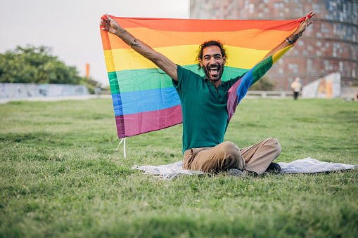 Happy man holding lgbtqia rainbow flag