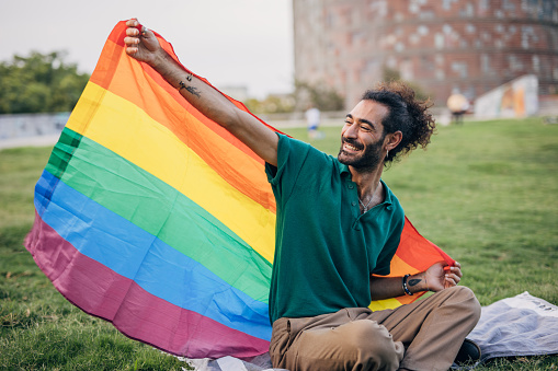 Happy man holding lgbtqia rainbow flag