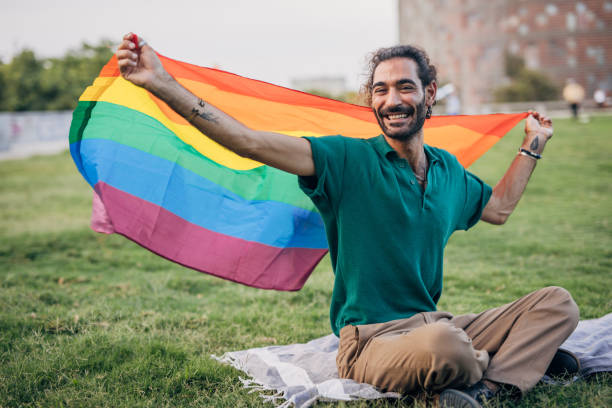 istock Happy man holding lgbtqia rainbow flag 1425820375