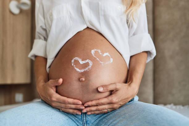 kobieta w ciąży biorąc jej brzuch - human pregnancy abdomen naked human hand zdjęcia i obrazy z banku zdjęć