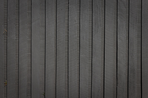 Section of a dark gray wooden fence.