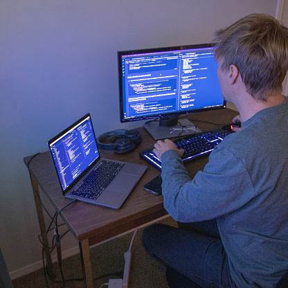 Young Man Uses Multiple Computers While Coding Developing Web Site ...
