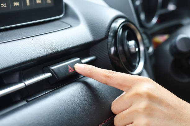 istock Close up hand press the emergency light in the car, Fingers press button.for open the contract emergency light in car. Emergency button press for open emergency light warning sign symbol out side car 1425830455