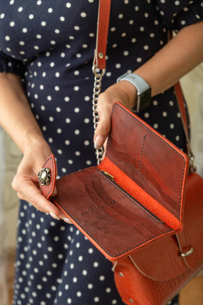 istock Woman holds an open brown natural leather wallet in her hands. 1425841477