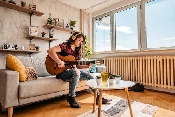 istock Man playing acoustic guitar at home 1425841512