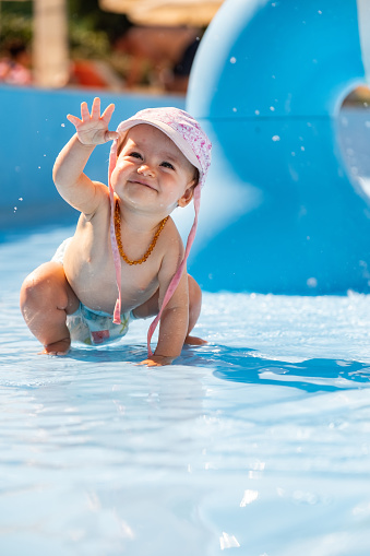 Happy baby girl having fun in a swimming pool
