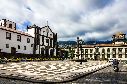 Funchal, Portugal - August 29, 2022: Funchal town Hall and yellow taxi, Madeira island