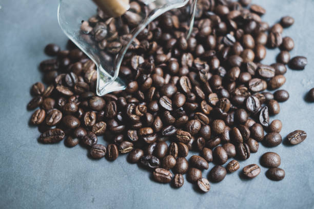 istock Coffee beans are scattered from a glsss mini cup 1425848265