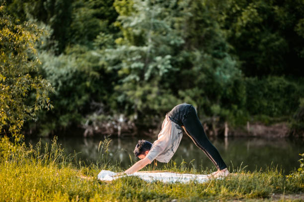 istock Young Woman Doing Yoga Outdoors By The River 1425848729