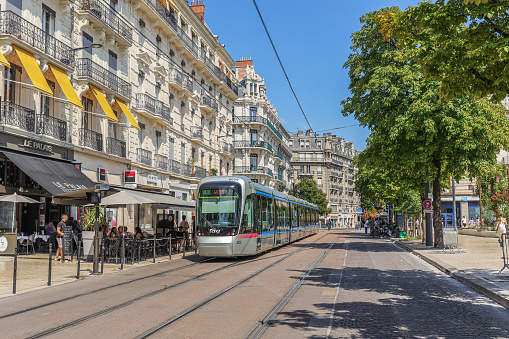 Grenoble, France- August 25, 2022: Modern tram drive down the street in the central part of the city.