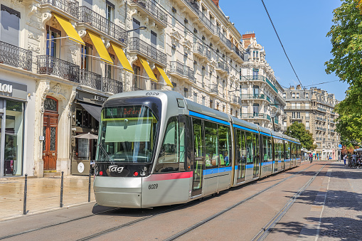Grenoble, France- August 25, 2022: Modern tram drive down the street in the central part of the city.