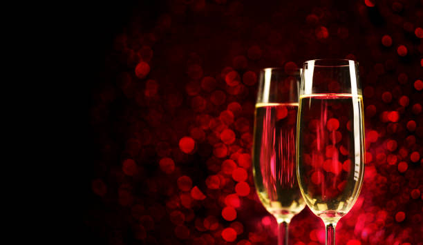 two champagne glasses on sparkling red bokeh background. valentine's day dinner, christmas and new year holiday party. - champagne champagne flute pouring wine imagens e fotografias de stock