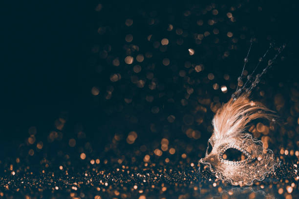 Luxury venetian mask on dark golden bokeh background. Luxury venetian mask on dark godlen bokeh background. New year and christmas party celebration design banner. Carnival masquerade fantasy costume ball. evening ball stock pictures, royalty-free photos & images