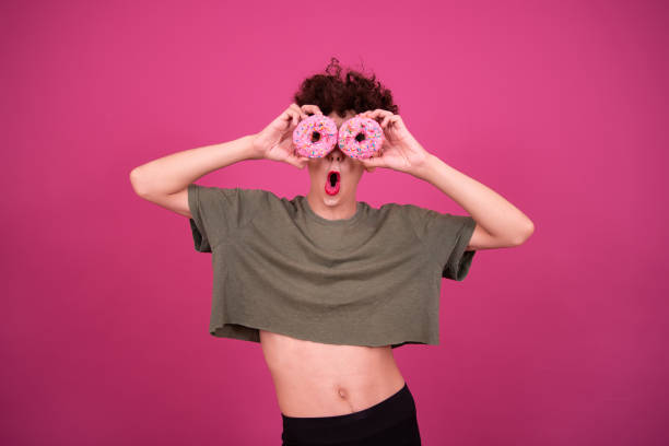 istock Cheerful drag queen with donuts. Pink background. 1425868701