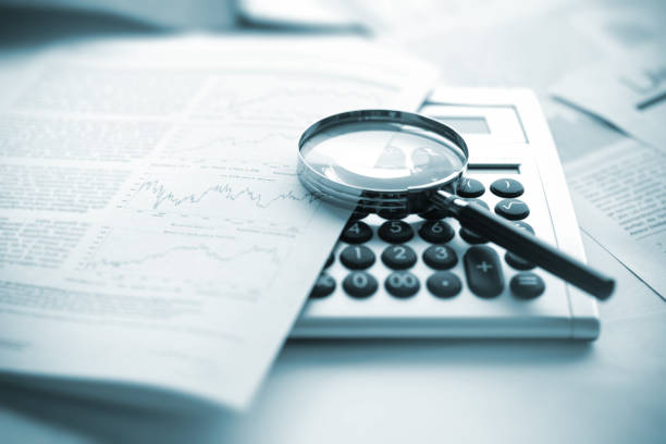 istock Magnifying glass, calculator and charts on paper 1425871418