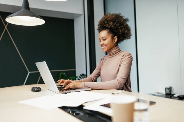 istock Smiling multiracial employee working in modern office on laptop 1425873247