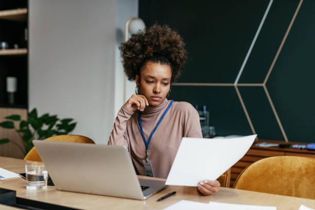istock Worried employee in office, looking at document and analyzing it 1425873637