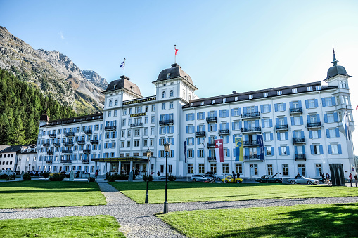 St. Moritz, Switzerland - 19th  September, 2019: The facade of the 5 star Grand Hotel Des Bains Kempinski on a beautiful clear day, with vintage cars parked in front