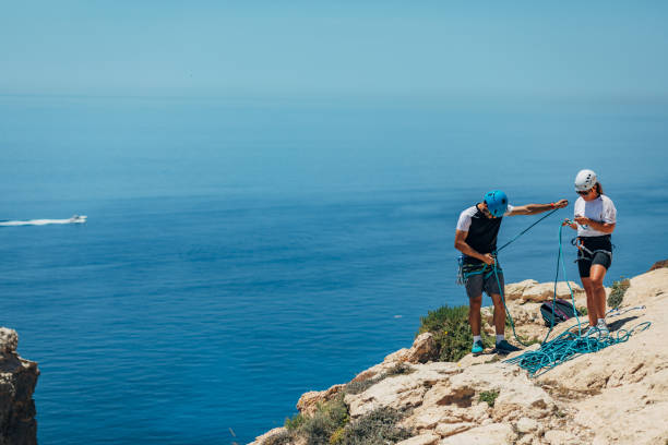 istock Climbers prepare to rappel above sea, using rope 1425879775